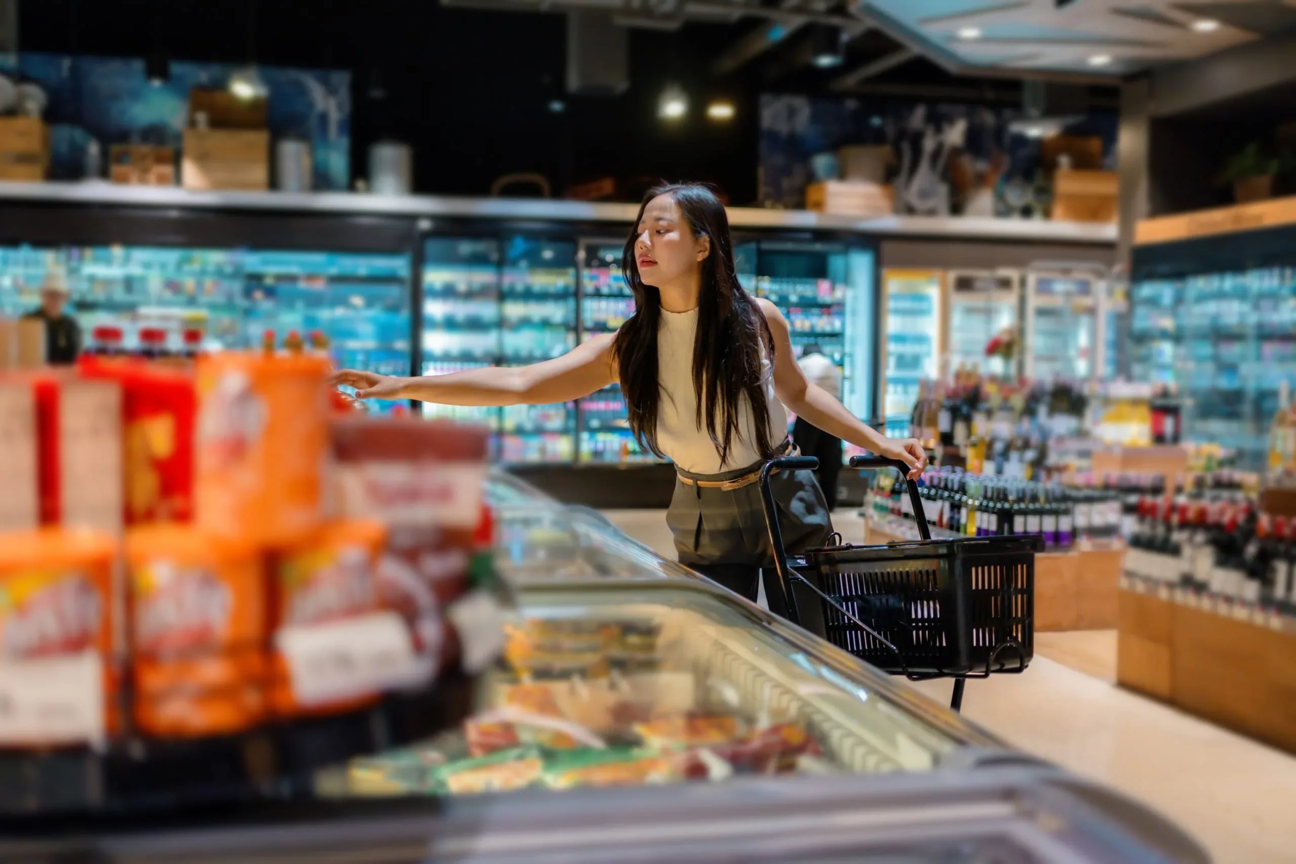 Shopper pushing a trolley along a supermarket aisle